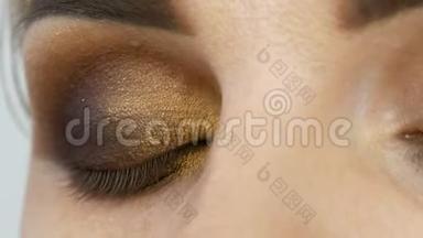 专业大师化妆师在美发沙龙上用米色眼圈配上指眼